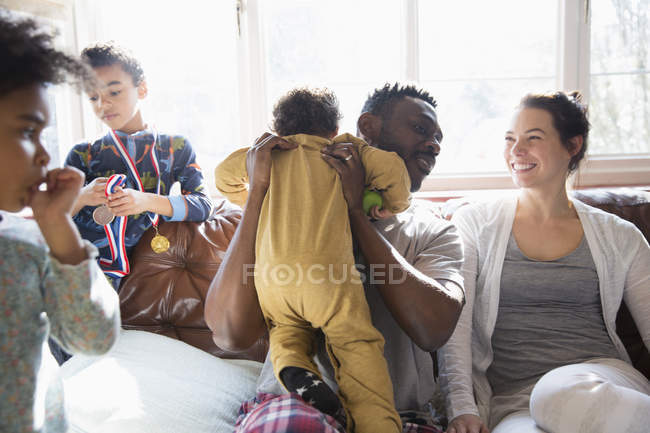 Счастливая многонациональная семья на диване — стоковое фото