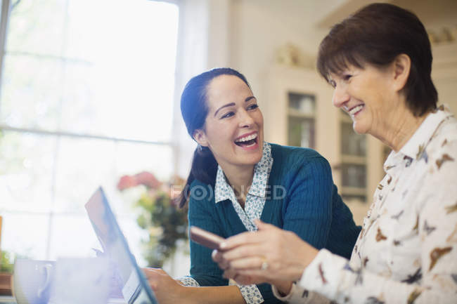 Glückliche Tochter hilft Seniorin mit Laptop — Stockfoto