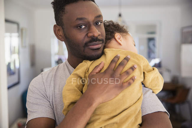 Retrato afetuoso pai segurando cansado bebê filho — Fotografia de Stock