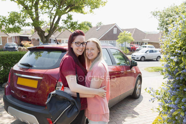 Portrait affectionate lesbian couple hugging in driveway — Stock Photo