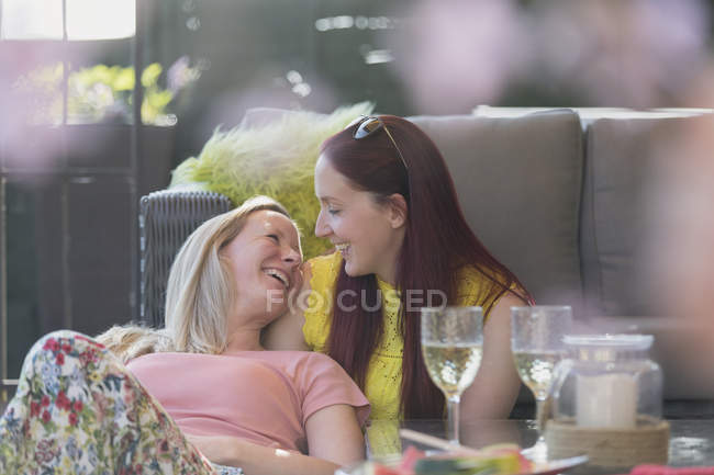 Cariñosa pareja lesbiana relajándose en patio - foto de stock