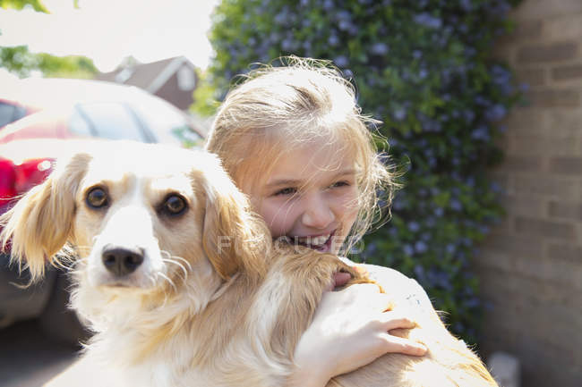 Щаслива дівчина обіймає собаку — стокове фото