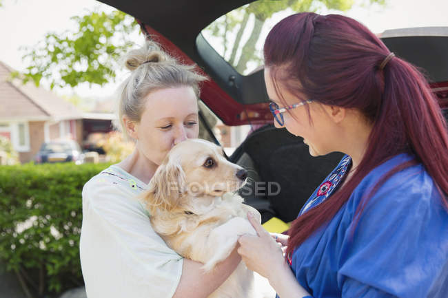 Lesbian couple and dog in driveway — Stock Photo
