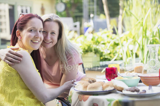 Porträt anhängliches lesbisches Paar genießt Mittagessen auf der Terrasse — Stockfoto