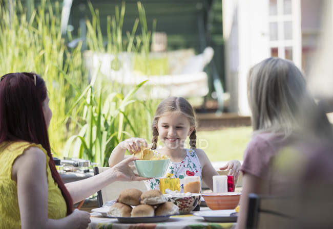 Coppia lesbica e figlia godendo il pranzo sul patio — Foto stock