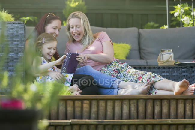 Lésbicas casal e filha usando tablet digital no pátio — Fotografia de Stock