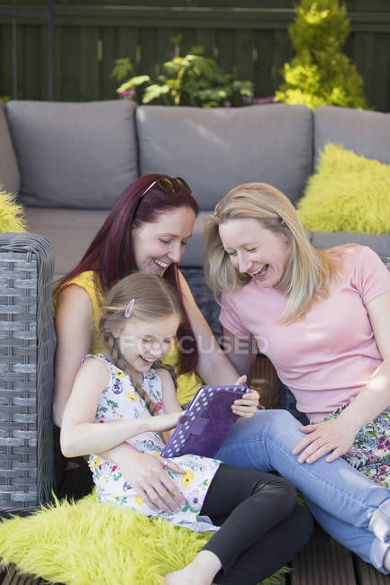 Пару лесбіянок і дочки, використовуючи цифровий планшетний патіо — стокове фото