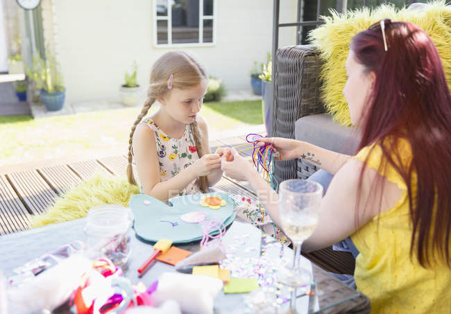 Mother and daughter doing craft project on patio — Stock Photo