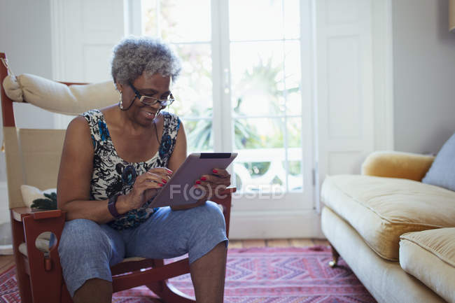 Seniorin nutzt digitales Tablet im Wohnzimmer — Stockfoto