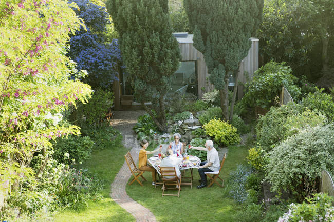 Amici anziani che si godono il pranzo in giardino — Foto stock