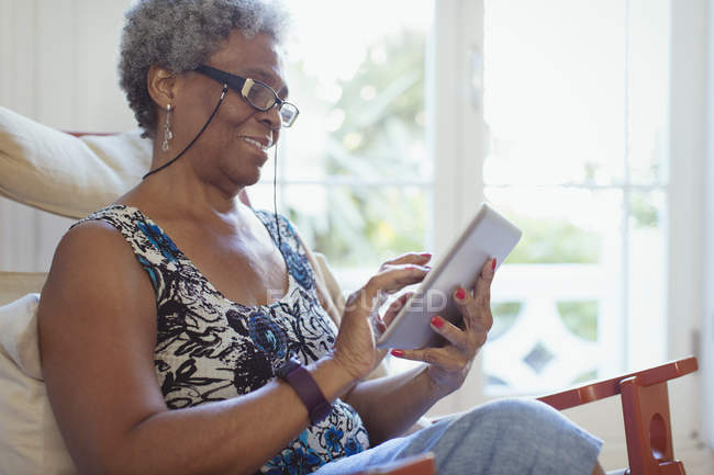 Seniorin nutzt digitales Tablet zu Hause — Stockfoto