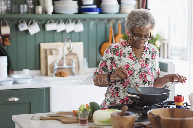 Femme âgée active cuisine dans la cuisine — Photo de stock
