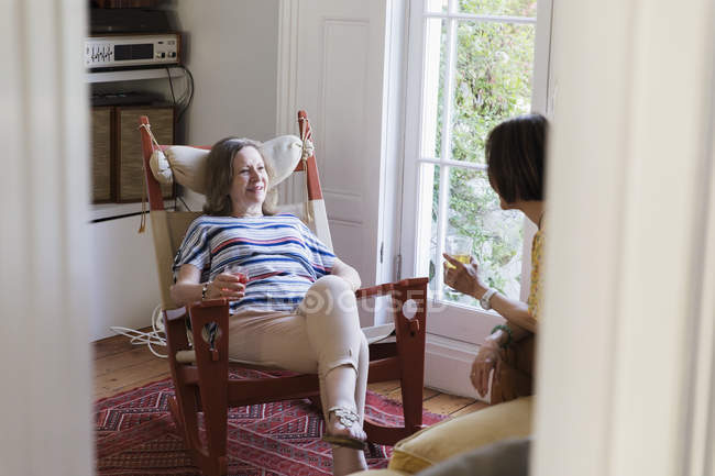 Літні жінки друзі розмовляють у вітальні — стокове фото