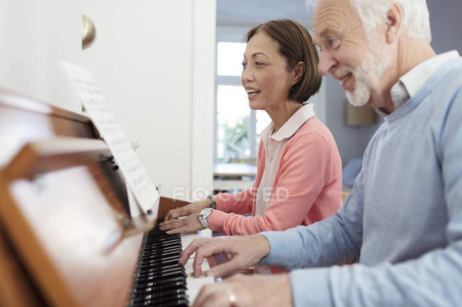 Coppia senior attiva che suona il pianoforte — Foto stock