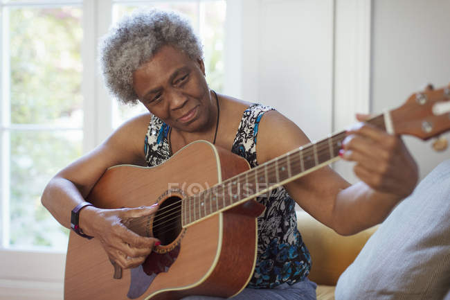 Активная старшая женщина играет на гитаре — стоковое фото