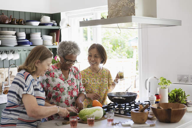 Mujeres mayores activas cocinando en la cocina - foto de stock