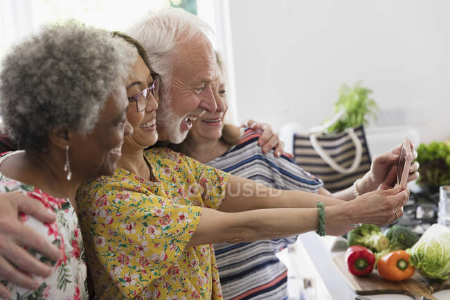 Счастливые старшие друзья делают селфи с камерой телефона — стоковое фото