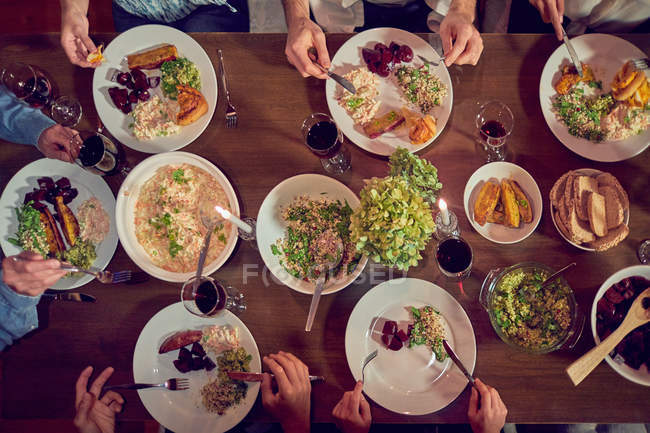 Вид зверху друзів насолоджується вечерею і червоним вином за столом — стокове фото