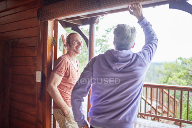 Père et fils parlent à la porte du patio de la cabane — Photo de stock