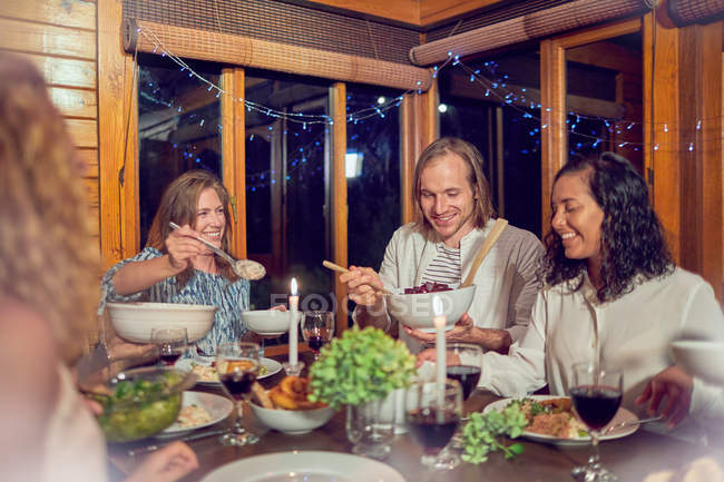 Friends enjoying dinner in cabin — Stock Photo