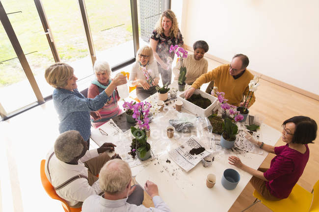 Активные пожилые люди наслаждаются классом аранжировки цветов — стоковое фото