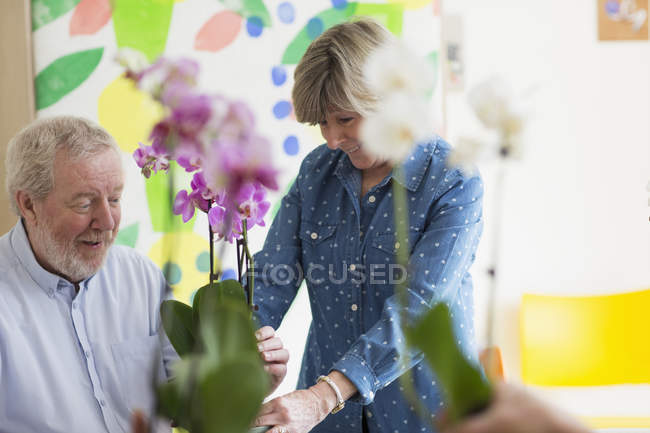 Активна старша пара насолоджується класом квіткових композицій — стокове фото
