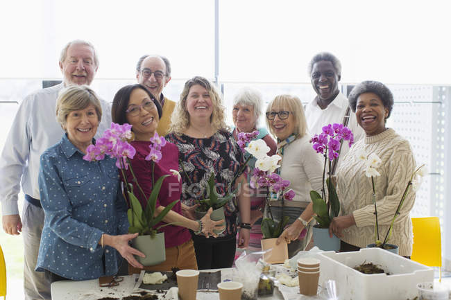 Retrato sonriente seniors activos disfrutando de la clase de arreglos florales - foto de stock