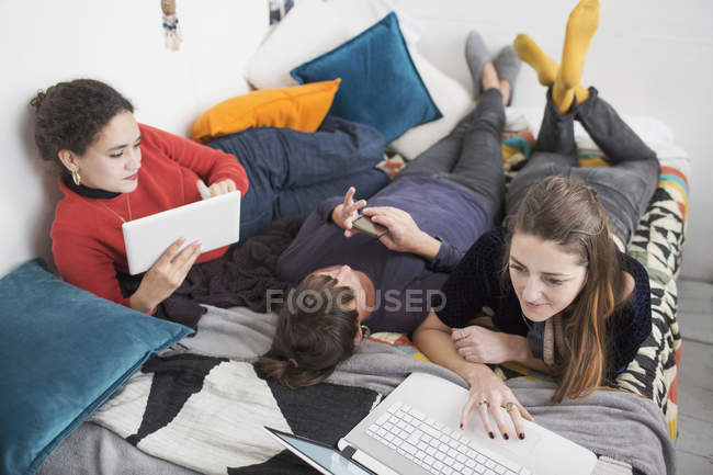 Jeunes femmes collège étudiants colocataires étudiant sur le lit — Photo de stock