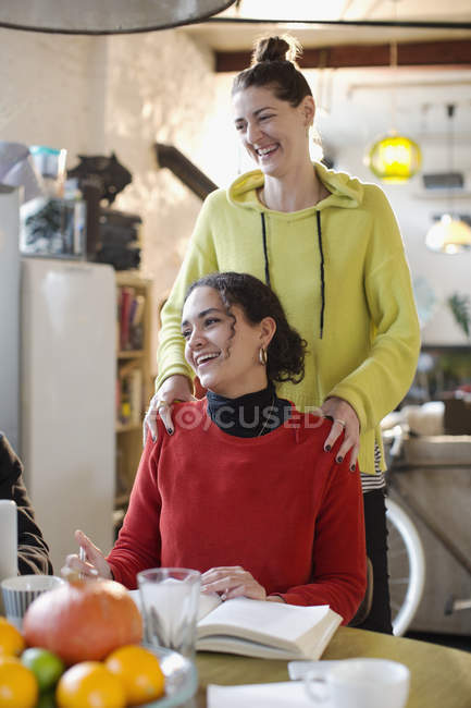 Smiling young women friends in apartment — Stock Photo