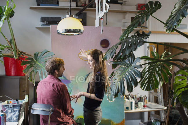 Artistas discutindo pintura em apartamento — Fotografia de Stock