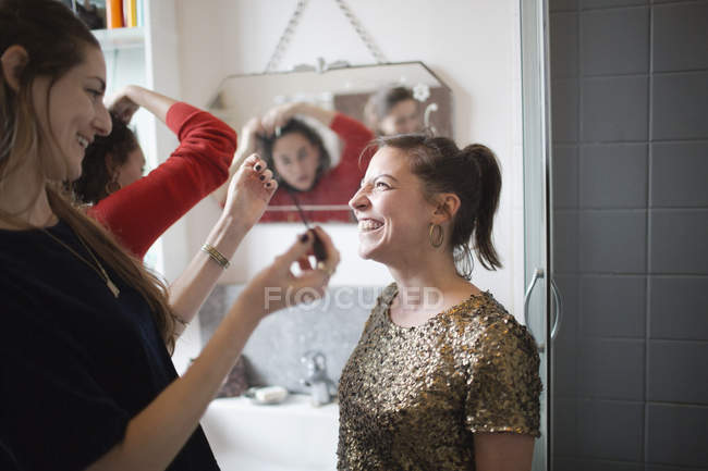 Молоді жінки друзі готуються, одягаючи макіяж у ванну кімнату — стокове фото
