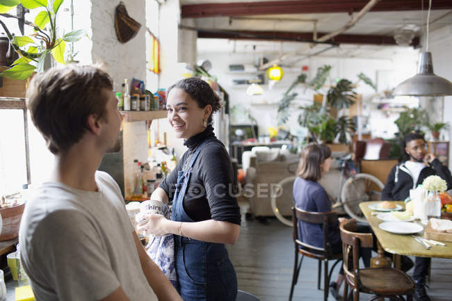 Young roommate friends doing dishes and talking in apartment kitchen — Stock Photo