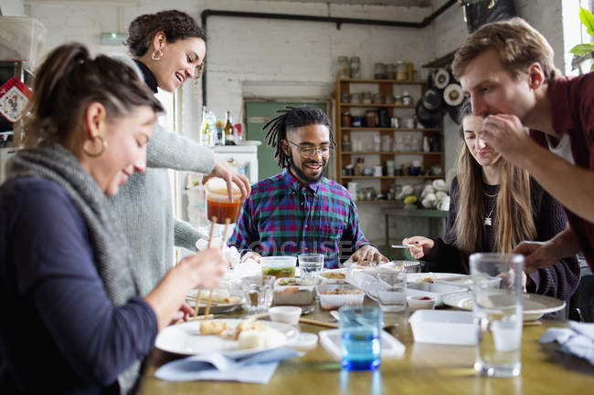 Junge Mitbewohnerinnen genießen Essen zum Mitnehmen am Küchentisch in Wohnung — Stockfoto