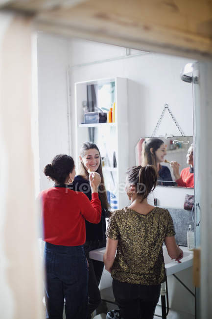 Jovens amigas se preparando, aplicando maquiagem no banheiro — Fotografia de Stock