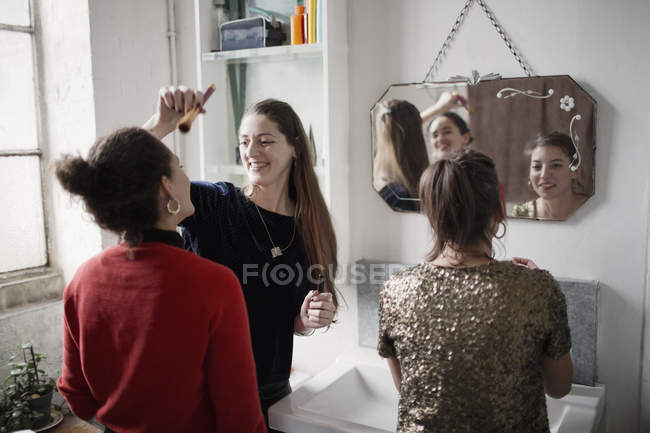 Young women friends getting ready, applying makeup in bathroom — Stock Photo