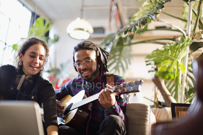Junge Männer und Frauen nehmen Musik auf, spielen Gitarre in der Wohnung — Stockfoto