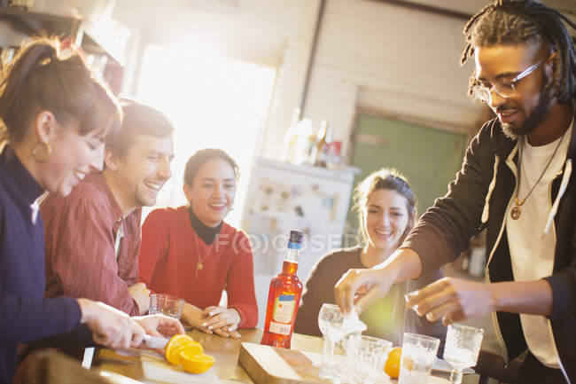Jovens amigos adultos fazendo coquetéis na mesa da cozinha — Fotografia de Stock