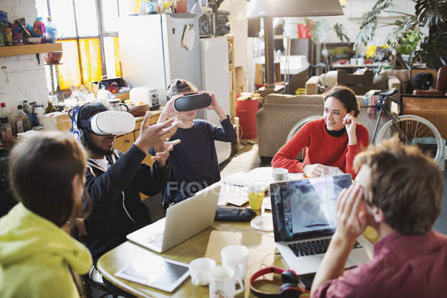 Jovens amigos estudantes universitários estudando, usando óculos simuladores de realidade virtual na mesa da cozinha no apartamento — Fotografia de Stock