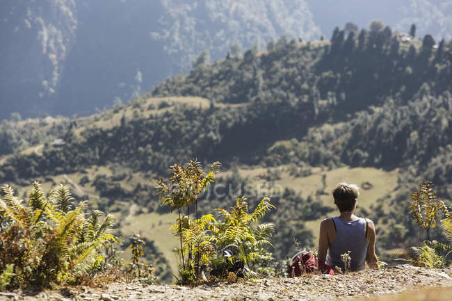 Caminhante do sexo feminino descansando, desfrutando de vista cênica ensolarada, Supi Bageshwar, Uttarakhand, Indian Himalayan Foothills — Fotografia de Stock