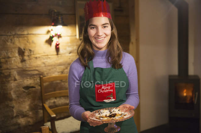 Portrait smiling teenage girl with fresh baked cookies — Stock Photo
