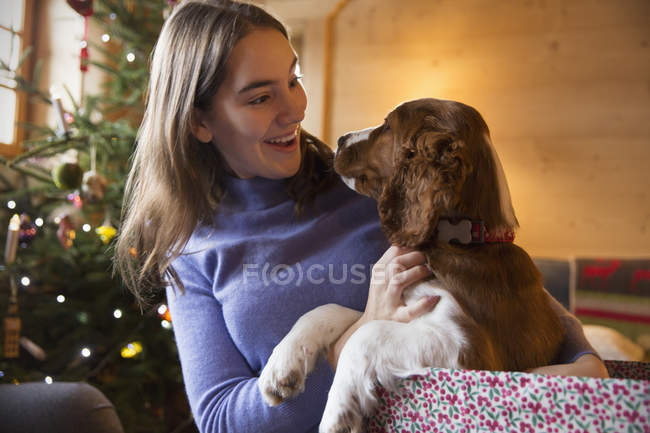 Adolescente caressant chien dans la boîte cadeau de Noël — Photo de stock
