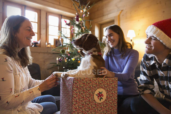 Happy family with dog in Christmas gift box — Stock Photo