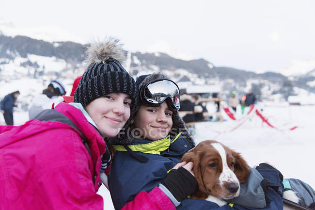 Ritratto fratello e sorella con cane sulla pista da sci — Foto stock