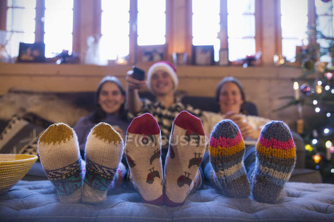 Family with colorful socks relaxing, watching TV in living room — Stock Photo