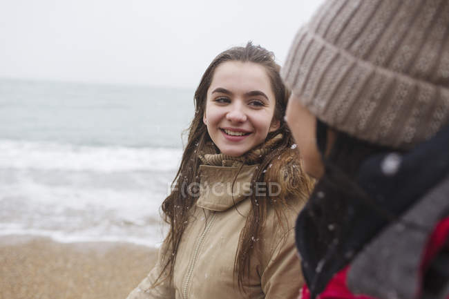 Mother and daughter walking on snowy winter beach — Stock Photo