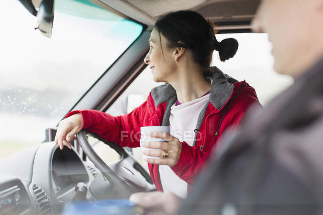 Mulher com café motor de condução para casa — Fotografia de Stock