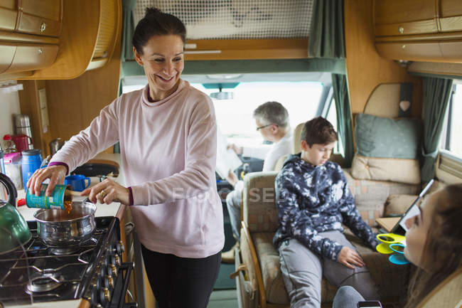 Happy family cooking and relaxing in motor home — Stock Photo