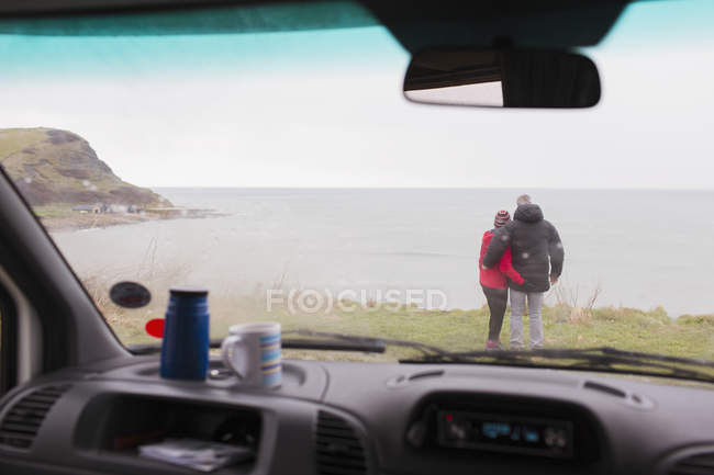 Ласковая пара наслаждается видом на океан за пределами дома на колесах — стоковое фото
