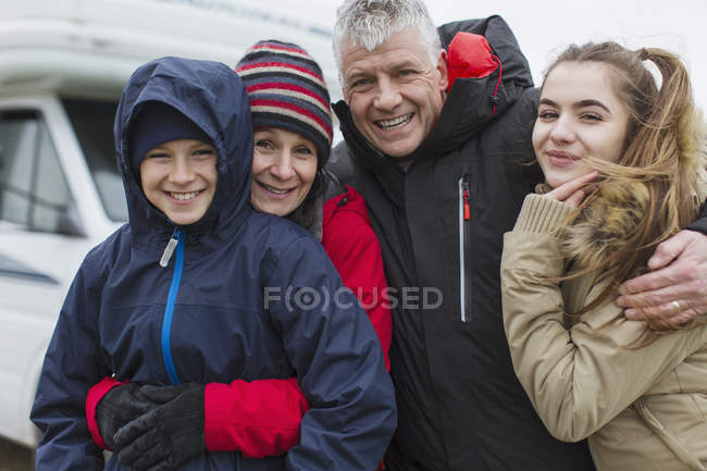Portrait affectionate happy family in warm clothing outside motor home — Stock Photo