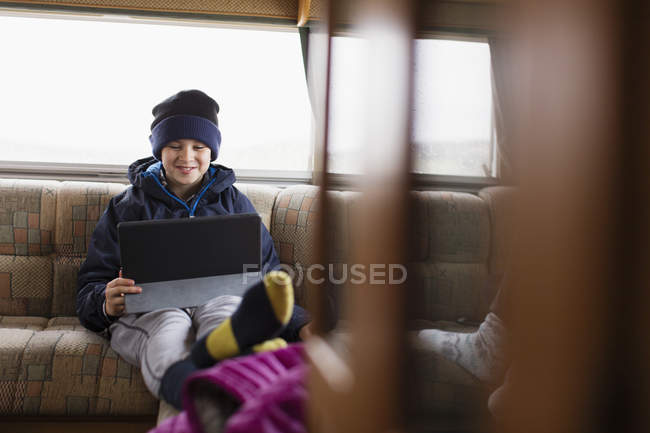 Adolescent garçon en utilisant tablette numérique dans la maison de moteur — Photo de stock